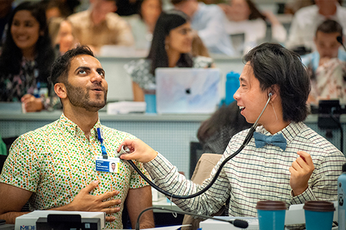 Two healthcare students taking each others vitals in a classroom