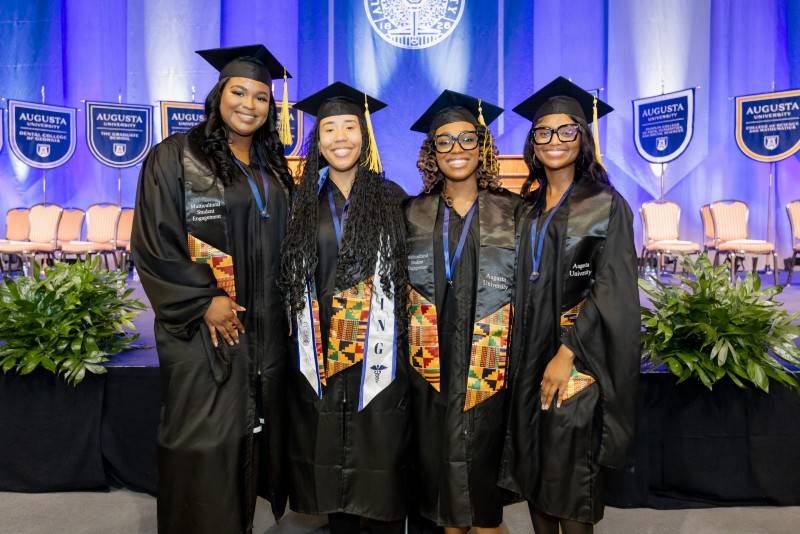four girls in graduation caps and gowns