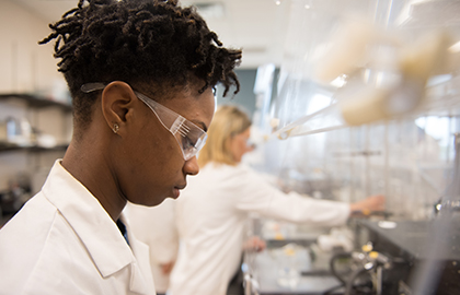 Student in lab with goggles on doing research