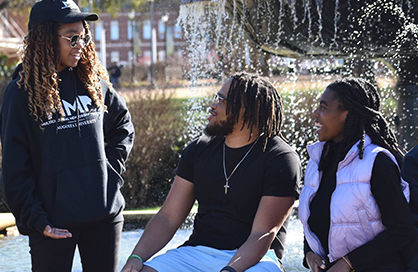 Students smiling and talking to each other on campus