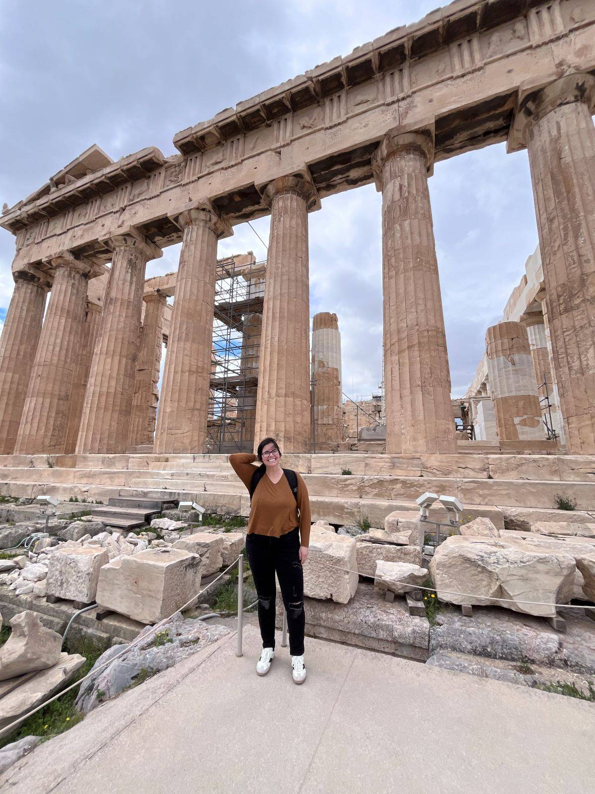 woman stands in front of the Parthenon in Athens, Greece