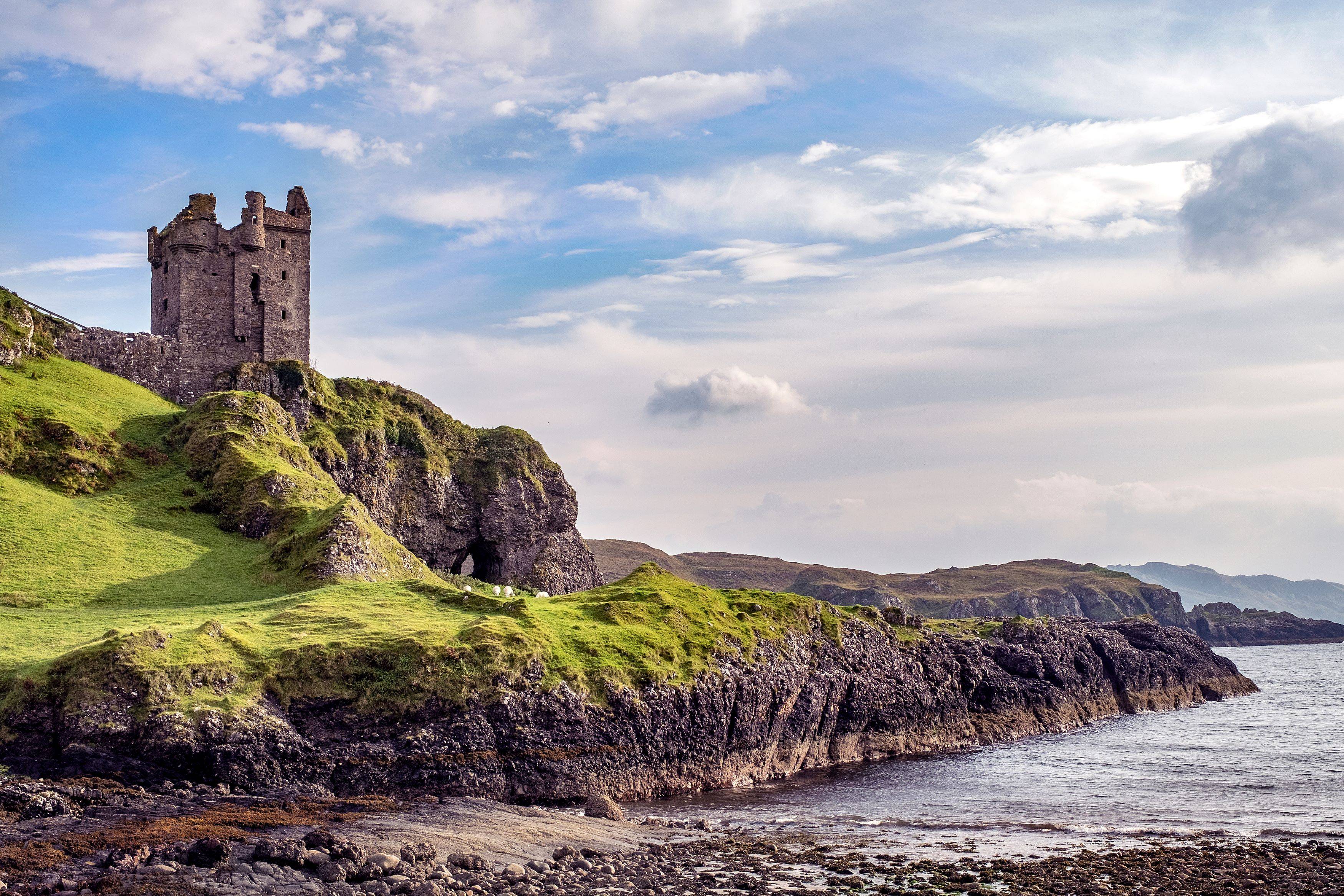 a castle sits upon a hill overlooking the sea