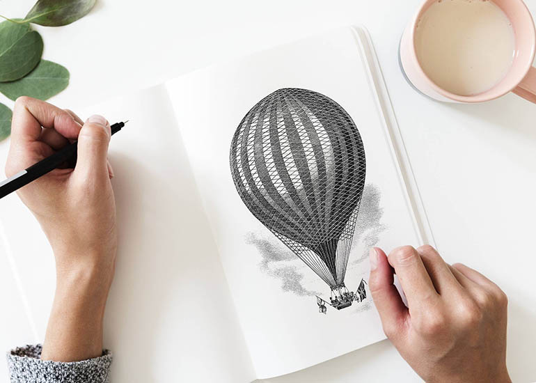 Hands drawing hot air balloon